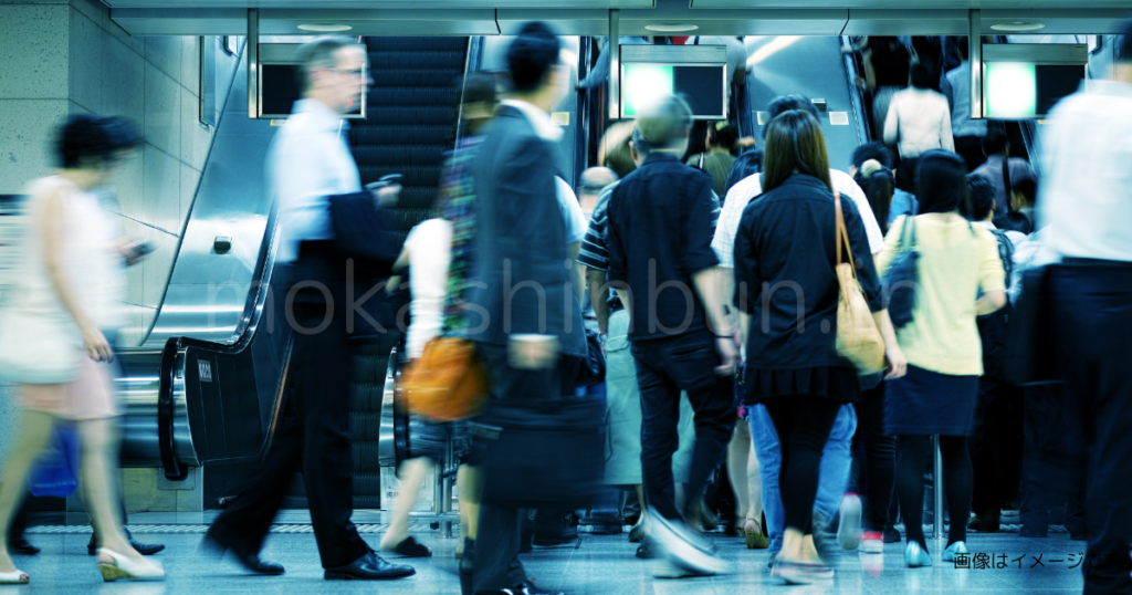 駅のエスカレーターに乗る人達